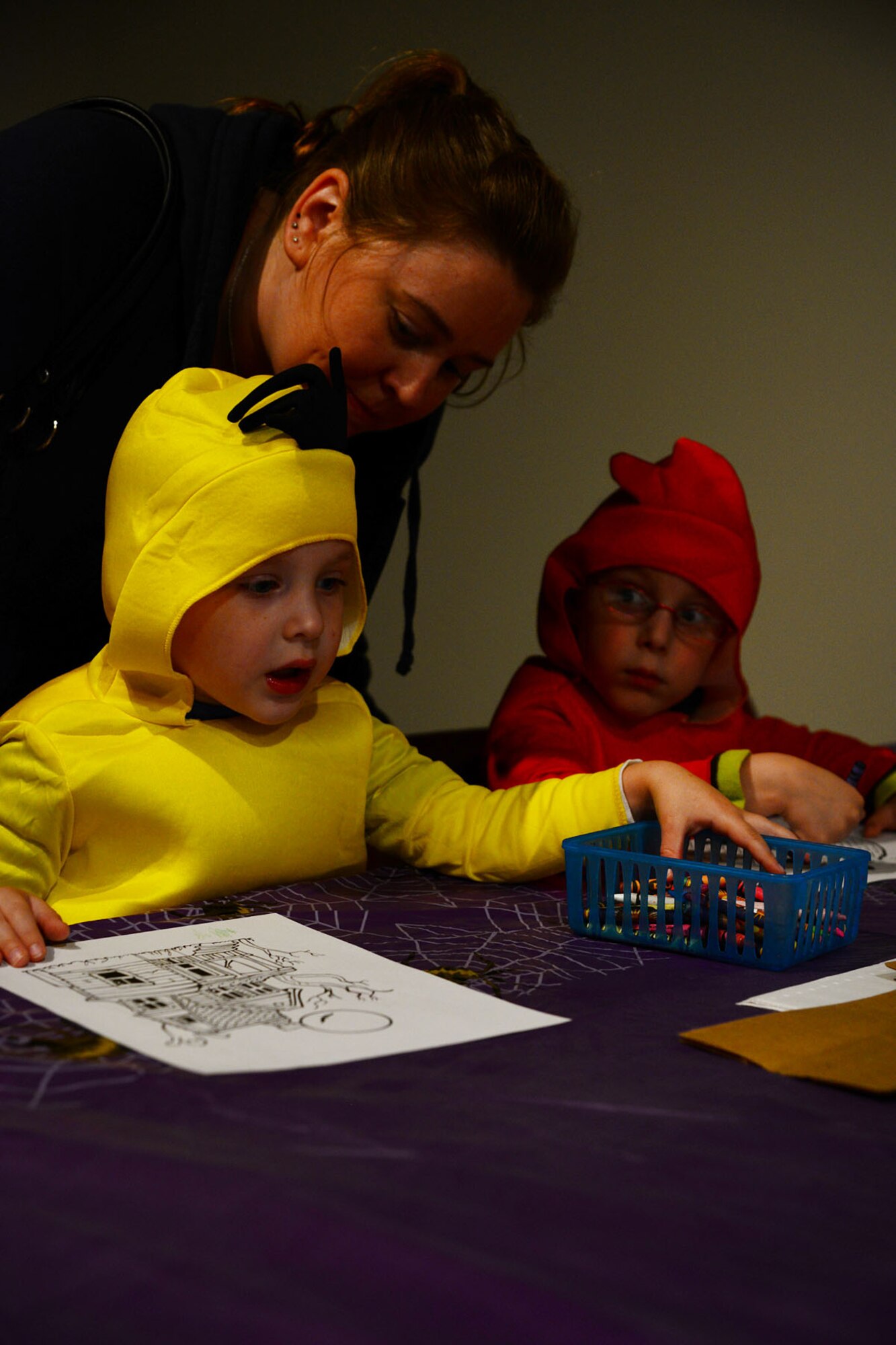 Meghan Hollingsworth helps her sons Logan, left, and Hunter color during the arts and crafts portion of the U.S. Army Transportation Museum's "Night at the Transportation Museum" event at Fort Eustis, Va., Oct. 28, 2013. Approximately 750 children attended the three-hour event, which included spooky exhibits, free candy, arts and crafts, and face painting. (U.S. Air Force photo by Staff Sgt. Ashley Hawkins/Released)