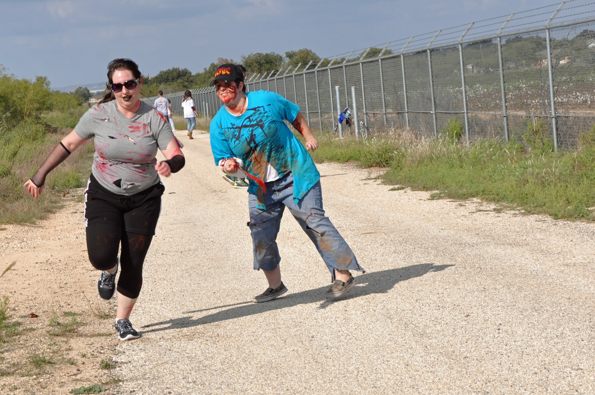 GOODFELLOW AIR FORCE BASE, Texas – Elizabeth Vest, Angelo State University student, grabs a flag off of a runner during the Zombie Run on Perimeter Road Oct. 27. This was the 2nd annual 17th Force Support Squadron Zombie Run. (U.S. Air Force photo/ Airman 1st Class Breonna Veal)