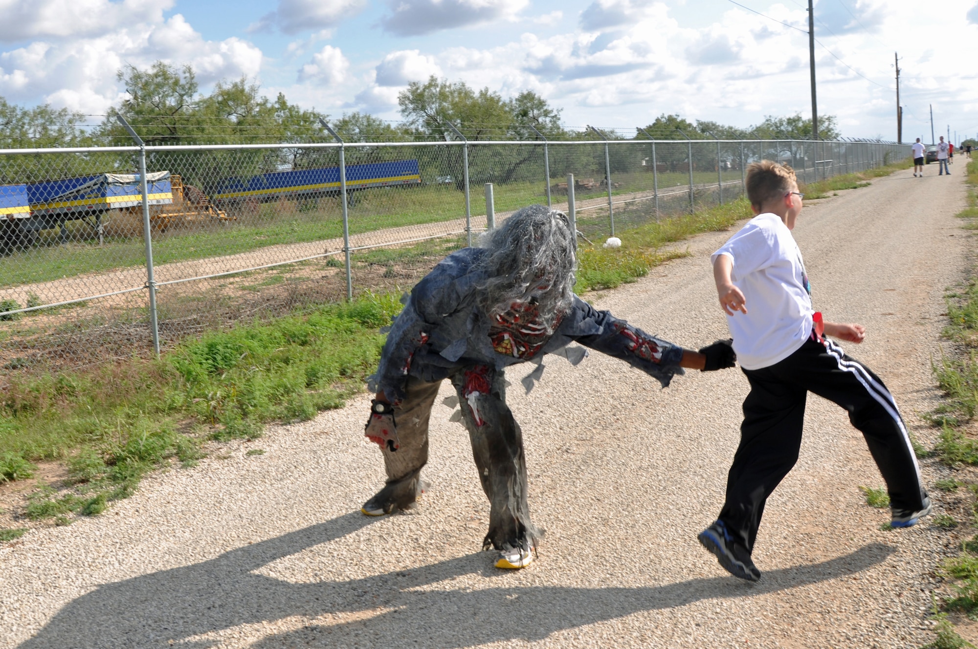 GOODFELLOW AIR FORCE BASE, Texas – Airman Terell Carter, 315th Training Squadron student, reaches for a runner’s flag during the Zombie Run on Perimeter Road Oct. 27. A free burger burn was provided after for zombies and humans alike. (U.S. Air Force photo/ Airman 1st Class Breonna Veal)