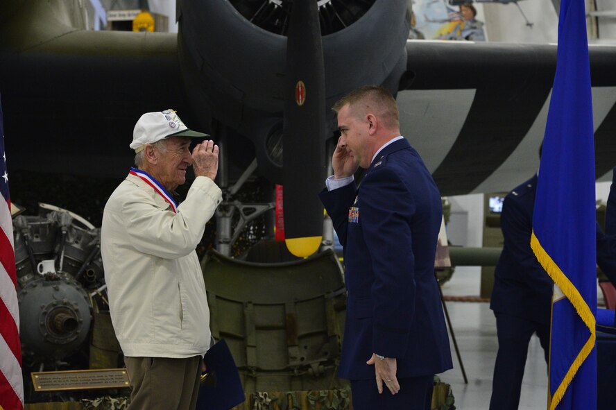 Bill Dando, a retired World War II veteran, salutes 1st Lt. Stephen Pike, 3rd Airlift Squadron pilot, after receiving a medal honoring his service Oct. 18, 2013, at the Air Mobility Command Museum on Dover Air Force Base, Del. Dando served as a pilot with the 41st Troop Carrier Squadron. (U.S. Air Force photo/David Tucker)