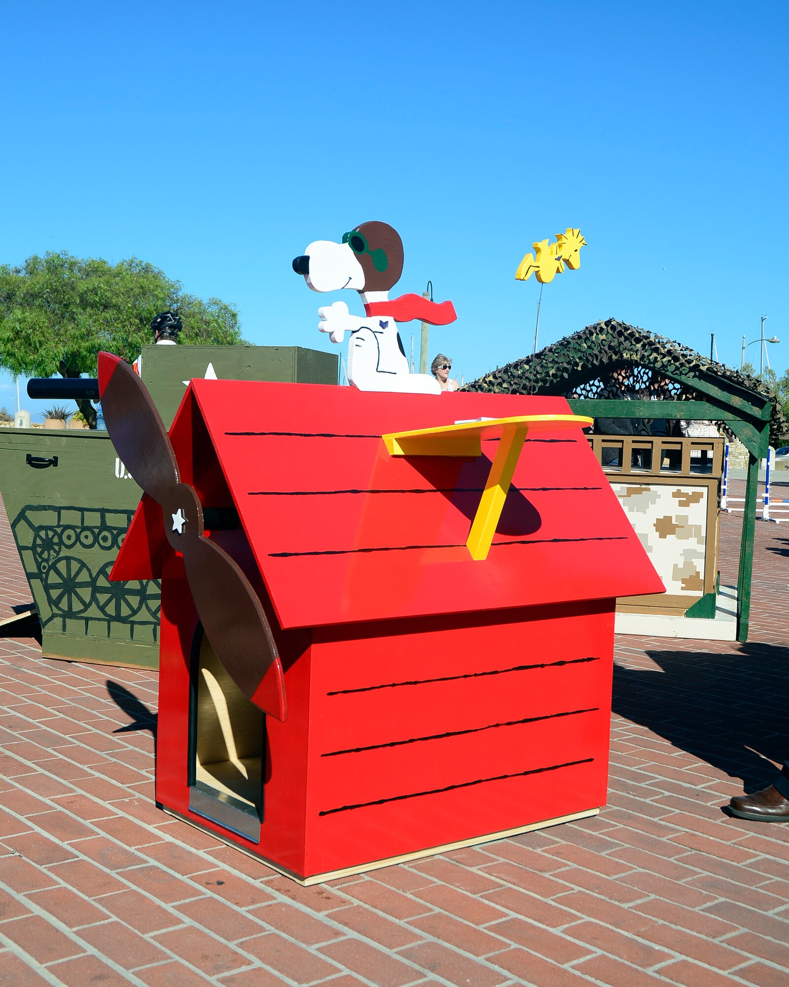 MONTEREY, Calif. -- The winning Air Force entry of Snoopy flying his Air Force Sopwith Camel dog house is backed on the left by the Army’s tank and the Marine Corps "Semper Fido" Oct. 13. The four entries are part of the fourth annual Monterey Dance for the Rescues military services dog house contest, a local animal rescue charity event on the Monterey wharf and comprised from contestants from the Defense Language Institute Foreign Language Center.  (Courtesy photo)

