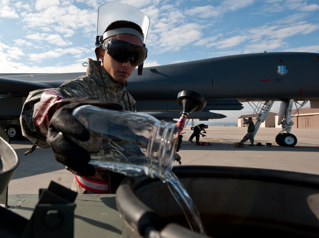 Airman 1st Class Peter Xiong, 28th Aircraft Maintenance Squadron crew chief, discards a fuel sample after inspecting a B-1 bomber sump for debris and other contaminants at Ellsworth Air Force Base, S.D., Oct. 24, 2013. If contaminants are found during the fuel test, the fuel must be drained and eliminated to ensure a B-1’s fuel burns better and cleaner, increasing the longevity of the aircraft. (U.S. Air Force photo by Airman 1st Class Alystria Maurer/Released)