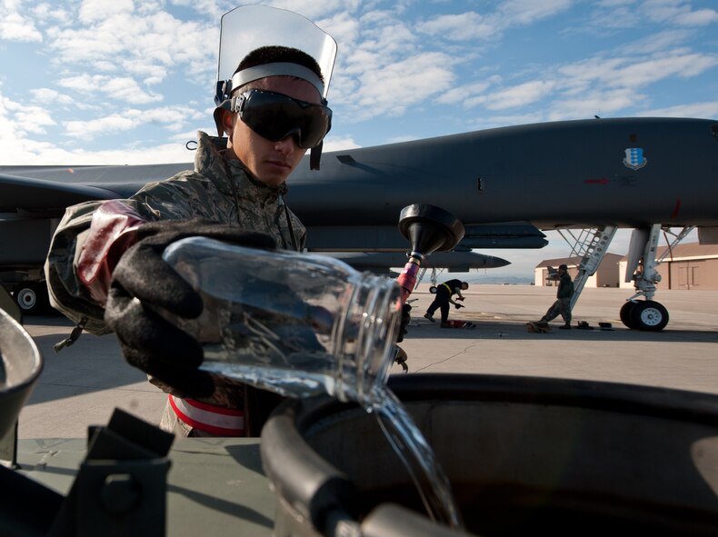 Airman 1st Class Peter Xiong, 28th Aircraft Maintenance Squadron crew chief, discards a fuel sample after inspecting a B-1 bomber sump for debris and other contaminants at Ellsworth Air Force Base, S.D., Oct. 24, 2013. If contaminants are found during the fuel test, the fuel must be drained and eliminated to ensure a B-1’s fuel burns better and cleaner, increasing the longevity of the aircraft. (U.S. Air Force photo by Airman 1st Class Alystria Maurer/Released)