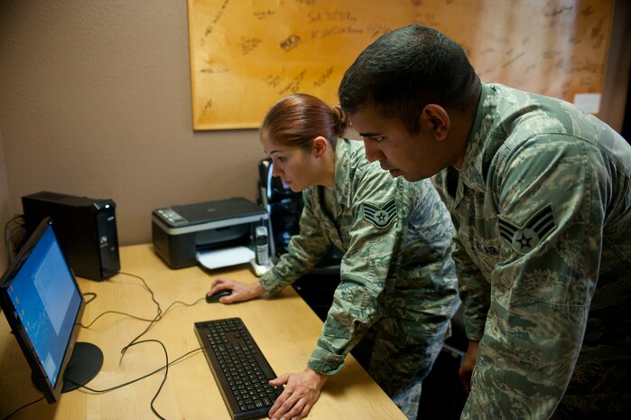 Staff Sgt. Jessica Brown and Senior Airman Thomas Jara, 99th Communications Squadron executive communication team members, set up the new Airmen Against Drunk Driving computer Oct. 28, 2013, in the Samek Airmen’s Center on Nellis Air Force Base, Nev. The new computer will help to log volunteer hours and coordinate pick-ups for Airmen who request a ride home from AADD. (U.S. Air Force photo by Staff Sgt. Michael Charles)