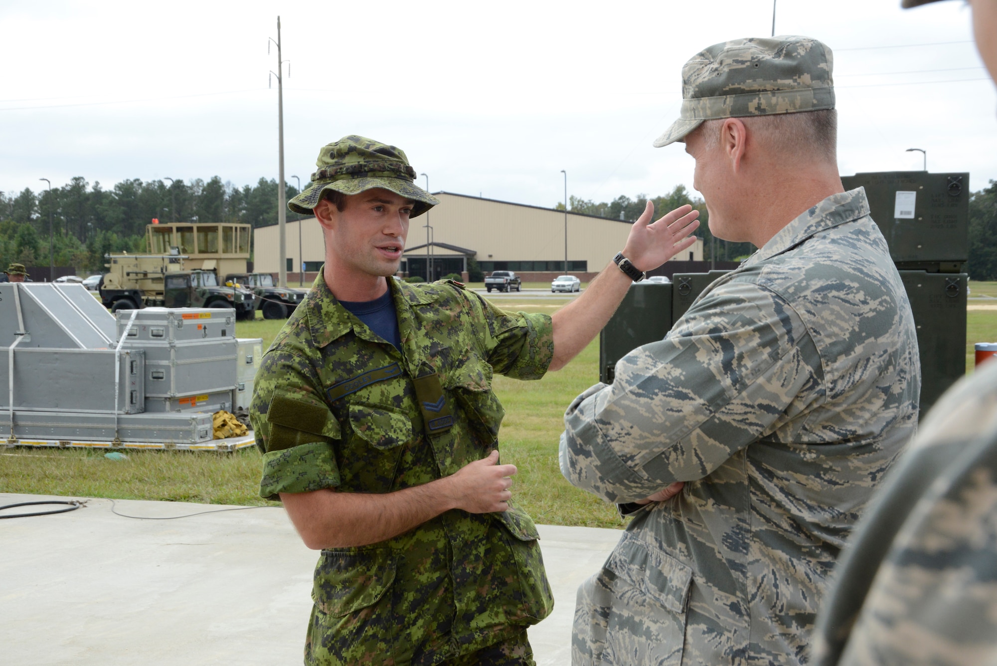 Royal Canadian Air Force Cpl. Nicholas Cooley briefs Col. Bill Waynick, 5th Combat Communications Group commander, on a communications satellite. (U.S. Air Force photo by Ed Aspera)
