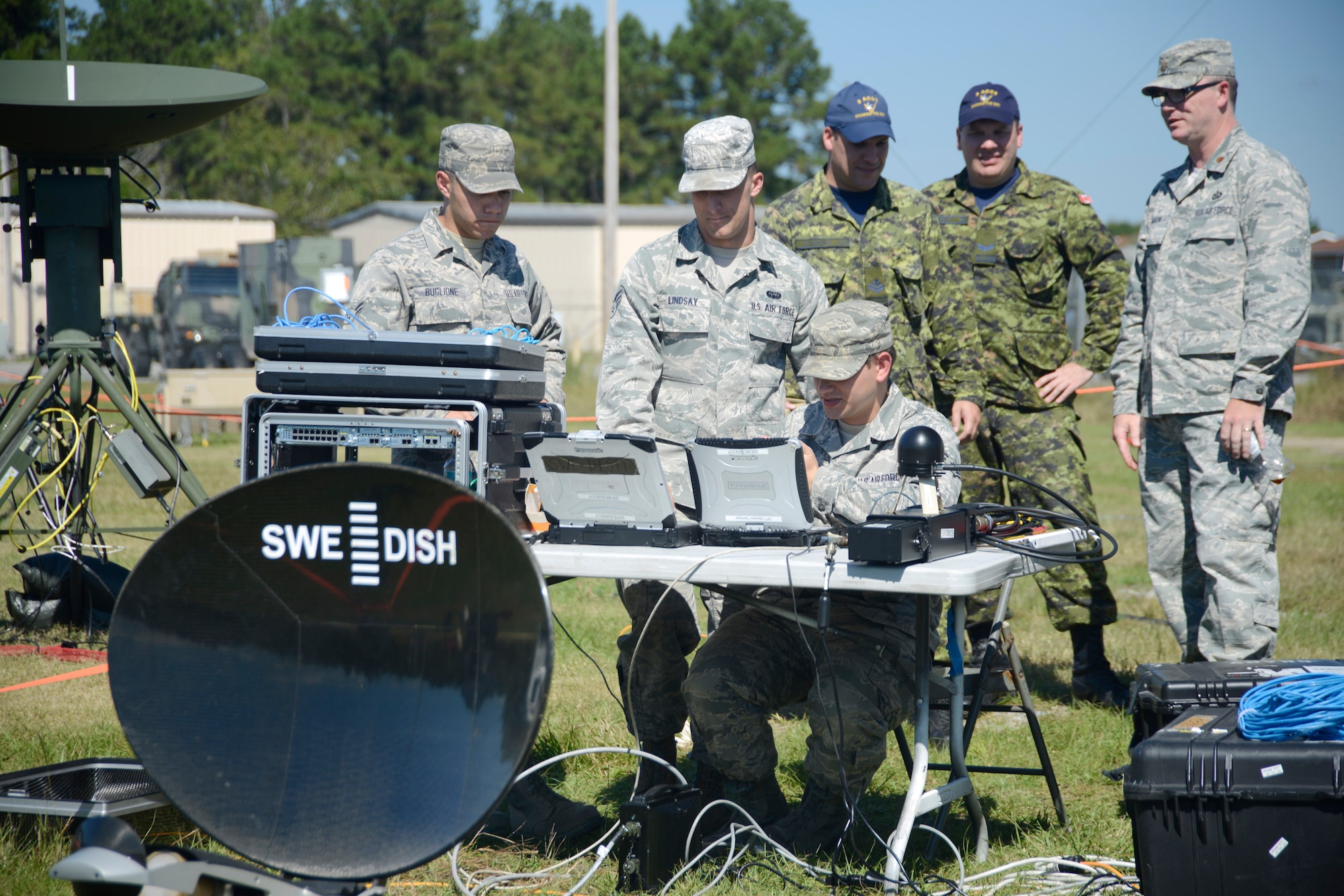 Members of the 5th Combat Communications Group and 8 Air Communication Control Squadron set up and position equipment to be used during their joint training event. (U.S. Air Force photo by Ed Aspera)


