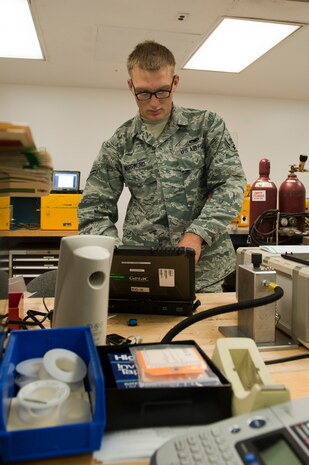 Airman 1st Class Chris Wahrmund, 57th Maintenance Squadron Precision Measurement Equipment Laboratory apprentice, calibrates a pressure-temperature test set at the PMEL Oct. 28, 2013, at Nellis Air Force Base, Nev. A pressure-temperature test set is used to test aircraft cockpit panels by simulating in-flight pressure conditions. (U.S. Air Force photo by Airman 1st Class Thomas Spangler)