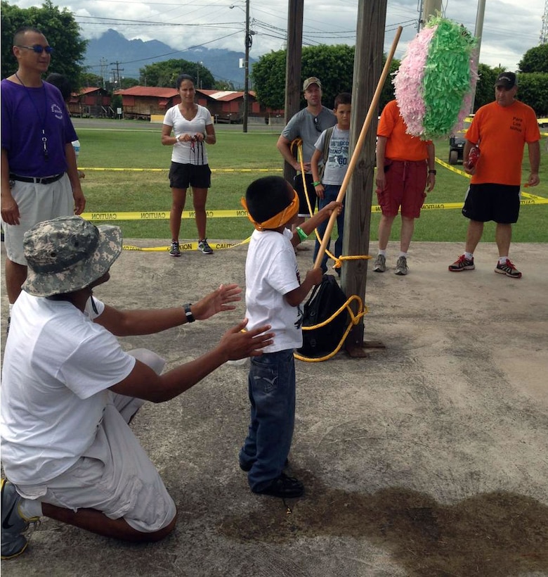 Members of Joint Task Force-Bravo's Medical Element (MEDEL) play with children from the Hogar Nazareth orphanage at Soto Cano Air Base, Honduras, Oct. 26, 2013.  MEDEL held a "Fiesta Day" for more than 60 children from the orphanage.  (Photo by U.S. Army Spc. Andrea Howard )