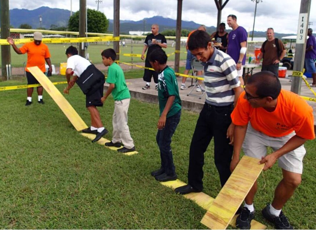 Members of Joint Task Force-Bravo's Medical Element (MEDEL) play games with children from the Hogar Nazareth orphanage at Soto Cano Air Base, Honduras, Oct. 26, 2013.  MEDEL held a "Fiesta Day" for more than 60 children from the orphanage.  (Photo by U.S. Army Sgt. Jennifer Shick)