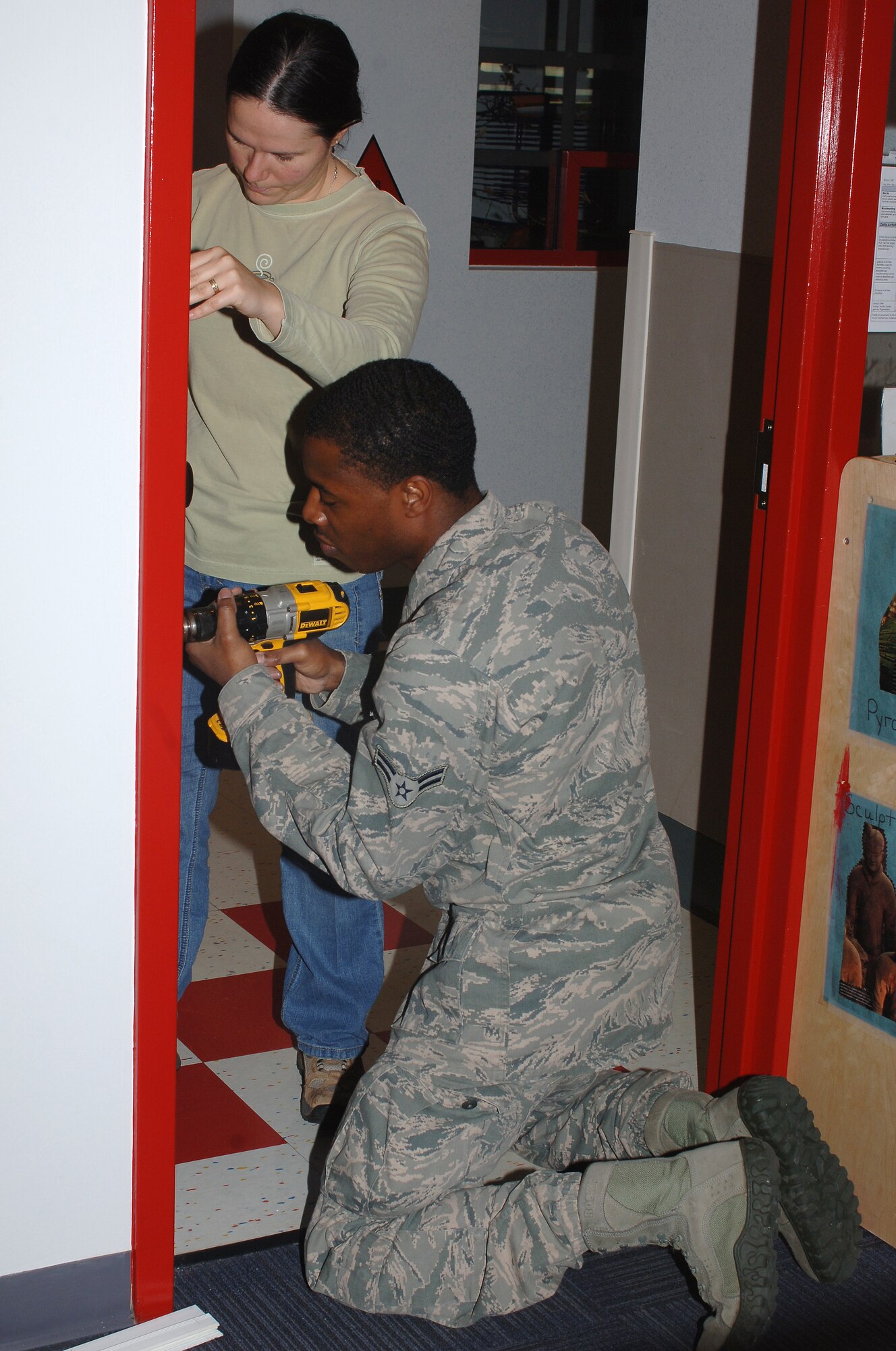 U.S. Air Force Staff Sgt. Danielle McAtee, 633rd Surgical Operations Squadron administrator, and Airman 1st Class Antwan Abdul-Rahmaan, 1st Maintenance Squadron low observable aircraft structural analyst, make minor repairs in classrooms at the Child Development Center at Langley Air Force Base, Va., Oct. 26, 2013. Throughout the volunteer CDC repair project, Airmen fixed broken cabinet doors and counter tops, replaced drawer stoppers and installed child-safe door jambs to ensure the safety of children in the CDC. (U.S. Air Force photo by Senior Airman Teresa Aber/Released)