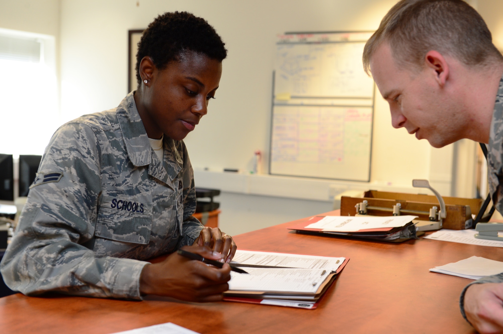 Airman 1st Class Jelissa Schools, 48th Logistics Readiness Squadron unit deployment manager, explains pre-deployment procedures with a customer at Royal Air Force Lakenheath, England, Oct. 28, 2013. Schools was nominated for a Liberty Spotlight because she displays the core value of “Service Before Self.” (U.S. Air Force photo by Airman 1st Class Dawn M. Weber/Released)