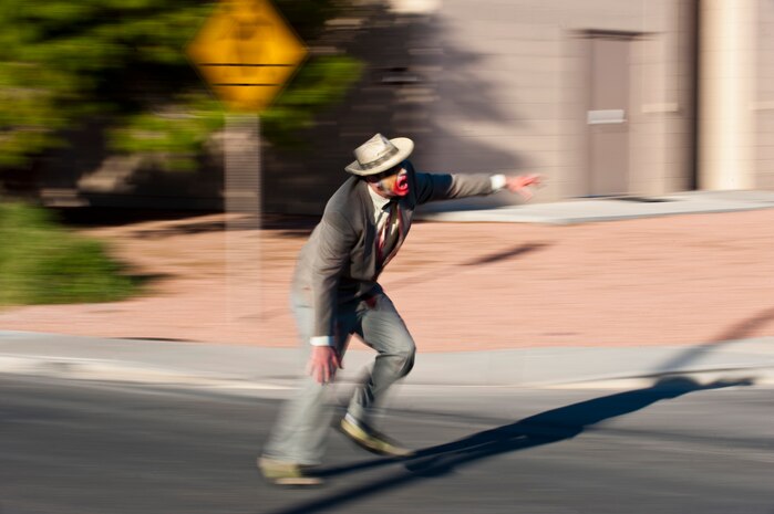 Staff Sgt. Ryan Stafford, 99th Aerospace Medical Squadron medical technician, chases a runner down Tyndall Road dressed as a zombie Oct. 26, 2013, at Nellis Air Force Base, Nev. The Zombie 5 kilometer run was hosted by the Nellis and Creech AFBs’ Dorm Council as a way to celebrate Halloween while encouraging fitness. (U.S. Air Force photo by Airman 1st Class Thomas Spangler) 