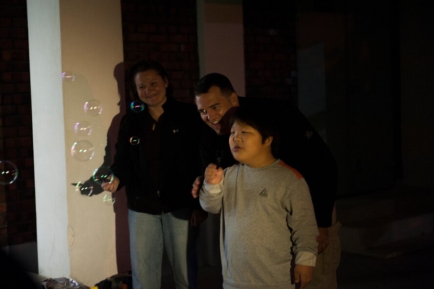 U.S. Navy Chaplain (Lt.) Travis Coffey, Marine Aircraft Group 12, plays with a child at the Ilmagwon Orphanage in Gunsan, Republic of Korea, Oct. 29, 2013. Kunsan Air Base Airmen and Marines and Sailors deployed to exercise Max Thunder teamed up to give back to the local community. (U.S. Air Force photo by Senior Airman Clayton Lenhardt/Released)