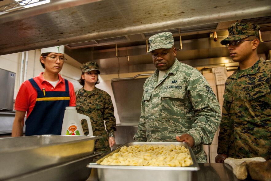 U.S. Air Force Tech. Sgt. Timothy Jones, 8th Force Support Squadron, inspects food prepared by U.S. Marine Corps Marines at the O'Malley Dining Facility, Kunsan Air Base, Republic of Korea, Oct. 29, 2103. The Marines are assisting the dining facility staff due to the increased number of patrons during exercise Max Thunder. (U.S. Air Force photo by Senior Airman Clayton Lenhardt/Released)