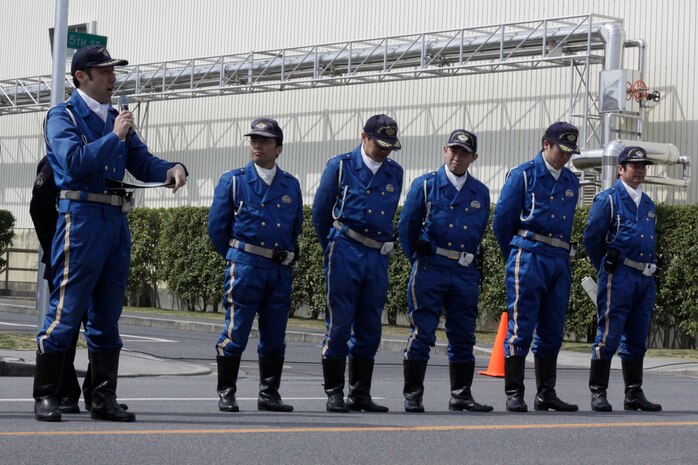 Ida Yoshikazu, Iwakuni police officer, talks to spectators about safety when driving off station on the road adjacent to the outside pool here March 22. Iwakuni police officers did demonstrations on being pulled over out in town and explained the differences between getting pulled over in America and Japan.