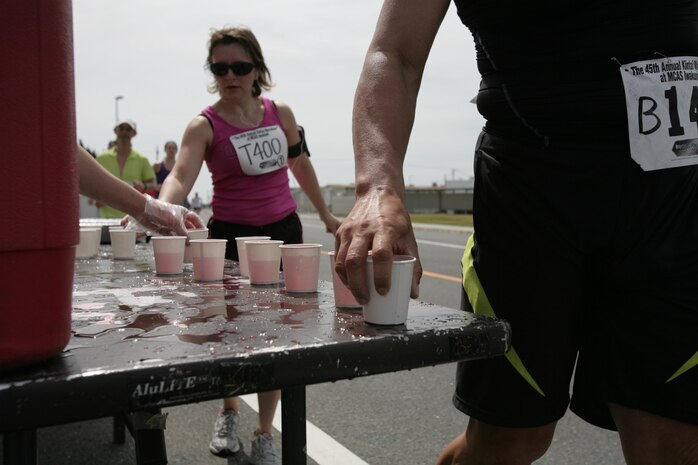 Racers grab water, sports drinks and snacks as they race by a hydration stand during the Kintai Marathon around Marine Corps Air Station Iwakuni April 15, 2012. Stands were placed along the track to keep runners’ bodies in the best condition during the race.