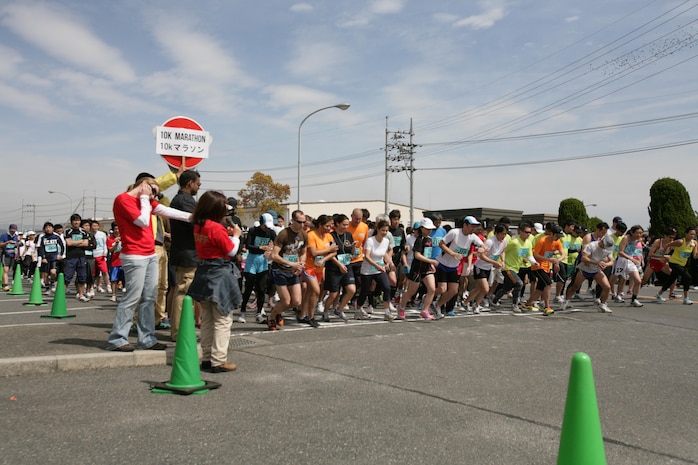 Racers take their first steps from the starting line while setting their watches to help pace themselves for the Kintai Marathon around Marine Corps Air Station Iwakuni April 15, 2012. There were five different classes, which separated runners by age.