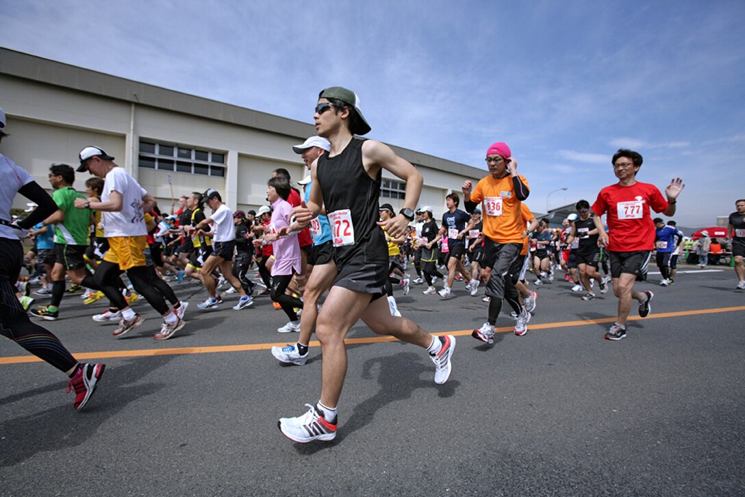 Racers take off from the starting line after setting their watches to help pace themselves for the 45th annual Kintai Marathon around Marine Corps Air Station Iwakuni April 15, 2012. Racers began clumped together, but the pack quickly thinned as many racers sped past or dropped behind the rest of the pack. The race isn’t about winning for some competitors; some just love the thought of completing the race. The ability for all of these racers to complete the 26-mile race takes training and keeps these runners fit and healthy.