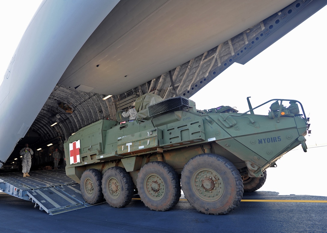 Army 1st Battalion, 14th Infantry Soldiers assigned to the 2nd Stryker Brigade Combat Team prepare to load a Stryker Medical Evacuation Vehicle aboard a C-17 Globemaster III during a validation exercise on the flightline at Joint Base Pearl Harbor Hickam, Hawaii, Oct. 17, 2013. The exercise was the first of its kind, and verified the C-17s assigned to the 535th Airlift Squadron could load and transport the combat vehicles and crew. 