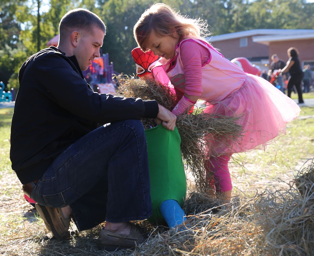 Cpl. Johnathon Martin helps children stuff a scarecrow during the Tarawa Terrace and Midway Park Community Centers’ Pumpkin Bash, aboard  Camp Lejeune, Friday.