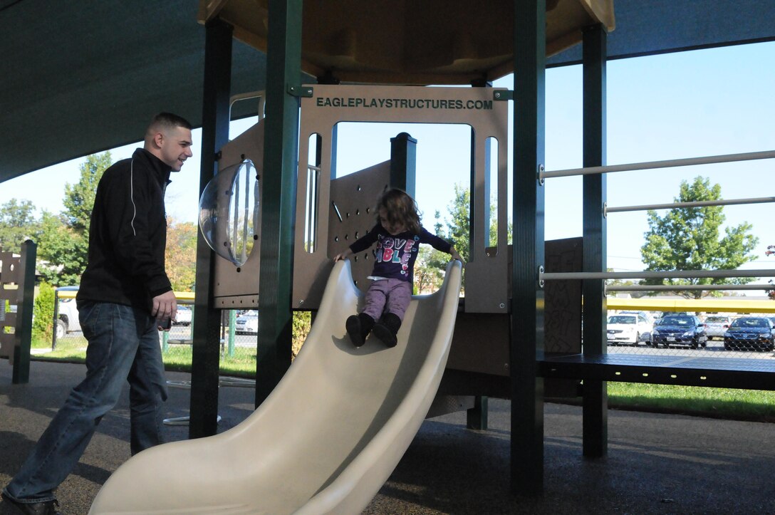 Auriana, 2, tries out one of the slides on the new playground on the morning of Oct. 21 while her father, Patrick Foster of Marine Helicopter Squadron 1, looks on. The playground opened in September, but the field won’t reopen until mid-December. 