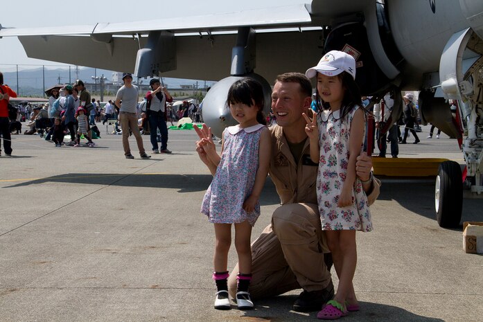 Capt. Timothy Farag, Marine Fighter Attack Squadron 242 pilot, poses for a picture with Japanese children during Friendship Day here May 5, 2012. Static displays and booths filled with food, clothing and other items blanketed the flight line along with more than 285,000 spectators, some traveling hundreds of miles to participate in the air show.