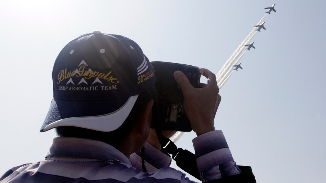 A Japanese spectator takes a photo of Blue Impulse during Friendship Day 2012 here, May 5, 2012. Friendship Day brought more than 285,000 spectators aboard the station to partake in static displays, American and Japanese vendors and a day-long air show.