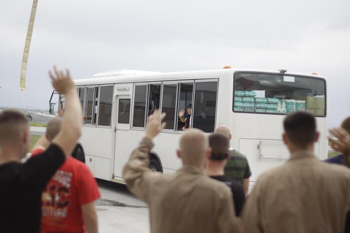 Aircraft Rescue Fire Fighting Marines wave goodbye to Tsuta orphanage children and chaperones as they leave the ARFF "barn" here July 14, 2012. ARFF Marines and their families took the orphanage children to the IronWorks Gym pool and to the air field where there station is located.