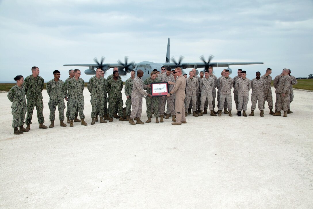 Lt. Col. Jason W. Julian, center right, presents a plaque of appreciation to Lt. Col. Nick Brown Oct. 28 at the Ie Shima Training Facility. Julian is the commanding officer of VMGR-152, MAG-36, 1st MAW, III MEF. Brown is the commanding officer of MWSS-172, 1st MAW.
(U.S. Marine Corps photo by Lance Cpl. Natalie M. Rostran/Released)
