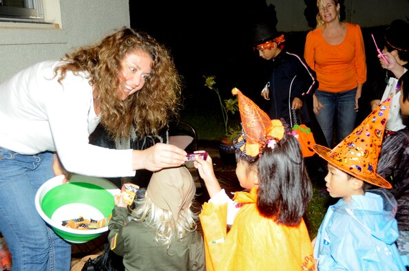 Kathleen Roesti hands out candy to local national trick-or-treaters during Halloween on Kadena Air Base, Japan, Oct. 31, 2013. Trick-or-treaters collected candy from families in the base housing areas. Some candy was donated through donation bins to be handed out in the base housing areas. (U.S. Air Force photo by Staff Sgt. Darnell T. Cannady)