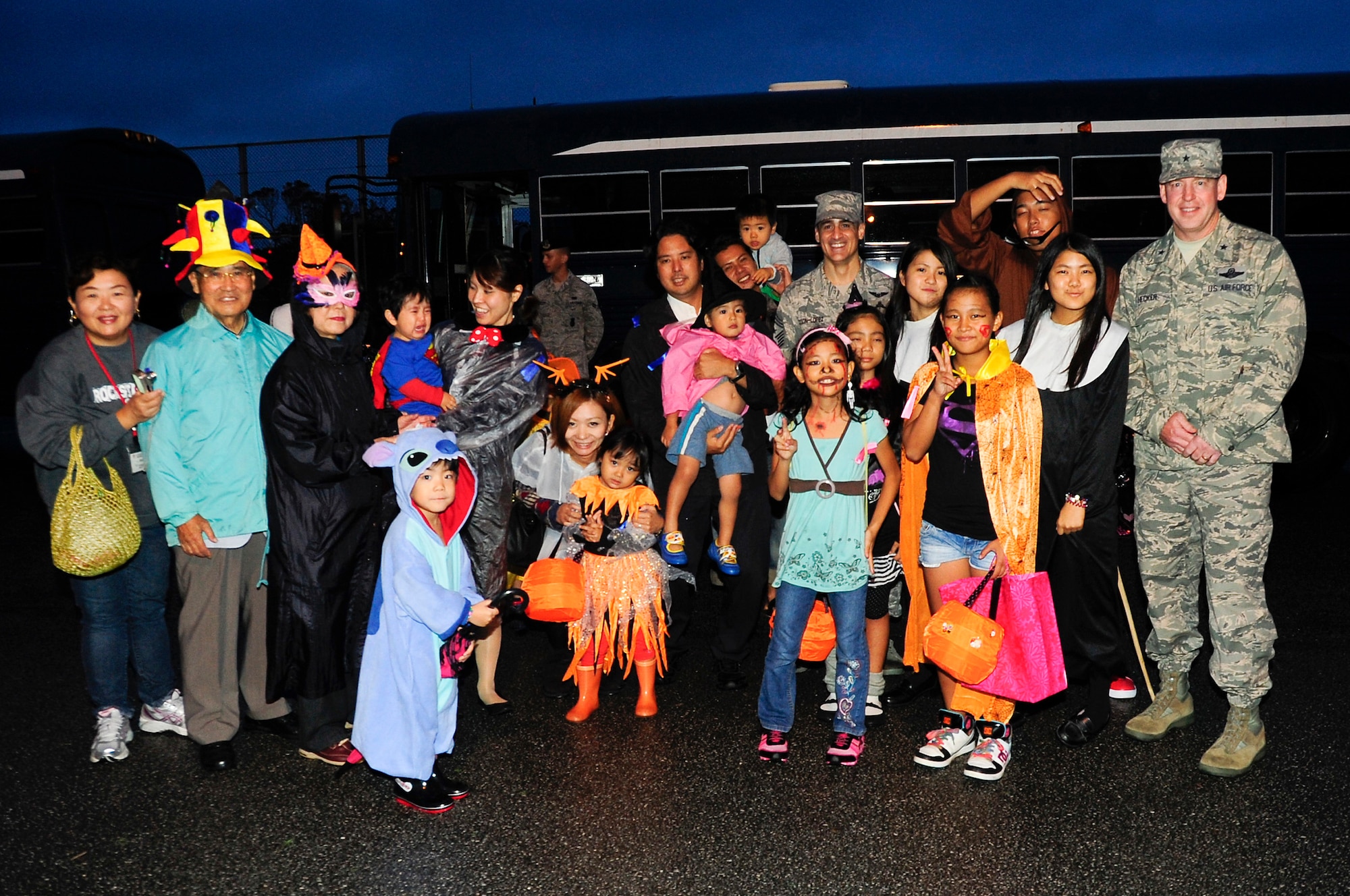 U.S. Air Force Chief Master Sgt. Ramon Colon-Lopez, 18th Wing command chief (middle), and Brig. Gen. James Hecker, 18th Wing commander, pose for a group photo with local national trick-or-treaters before the Halloween festivities hosted on Kadena Air Base, Japan, Oct. 31, 2013. Kadena hosted more than 180 local trick-or-treaters for these Halloween festivities. Kadena transported local community children on base to experience this holiday. (U.S. Air Force photo by Staff Sgt. Darnell T. Cannady)