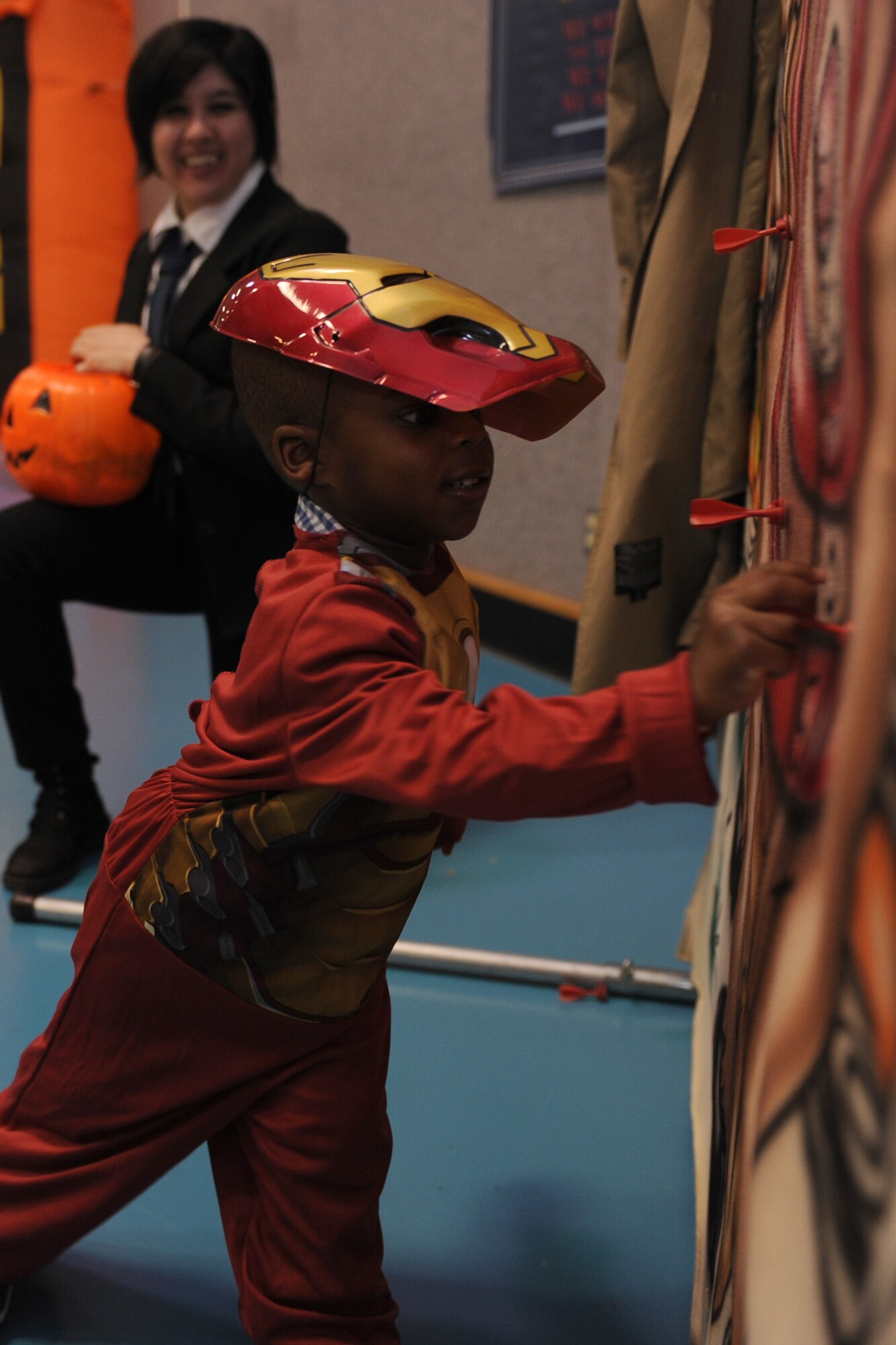 Kareen Nunn, 2; dependent of Tech. Sgt. Lateshia Nunn, 341st Force Support Squadron career development supervisor; pins the tail on a donkey at the bull’s eye station during the annual fall festival at the youth center Oct. 25. Karen was dressed up as Ironman for the event, which awarded prizes for best costume in different age categories. (U.S. Air Force photo/Senior Airman Katrina Heikkinen)