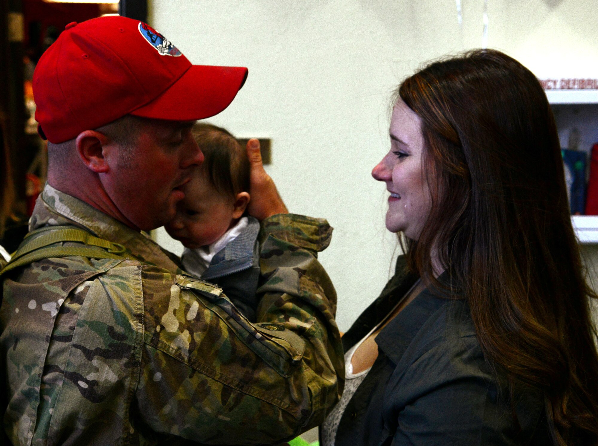 Senior Airman Joshua Byers, 819th RED HORSE Squadron pavement and equipment apprentice, holds his newborn son for the first time while his wife, Amanda, shares the moment. Byers returned to Malmstrom Air Force Base on Oct. 24 after his nearly seven-month deployment. (U.S. Air Force photo/Staff Sgt. R.J. Biermann)