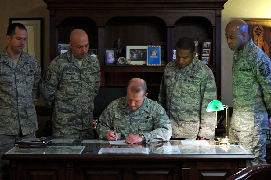 Col. Robert Stanley, 341st Missile Wing commander (center), signs a proclamation to recognize the dedication of medical administrative personnel across the base and declare Oct. 28 through Nov. 1 Medical Service Corps/Medical administration appreciation week as 341st Medical Group personnel look on.  Standing from left to right are Master Sgt. John Whitney, 341st Medical Support Squadron medical logistics and readiness flight chief; Master Sgt. Keith Stolberg, 341st MDG medical logistics technician; Maj. Eric Doggett, 341st MDSS logistics and readiness flight commander; and Master Sgt. Kamau Joseph, 341st MDSS TRICARE operations and patient administration flight chief.  (U.S. Air Force photo/Senior Airman Cortney Paxton)
