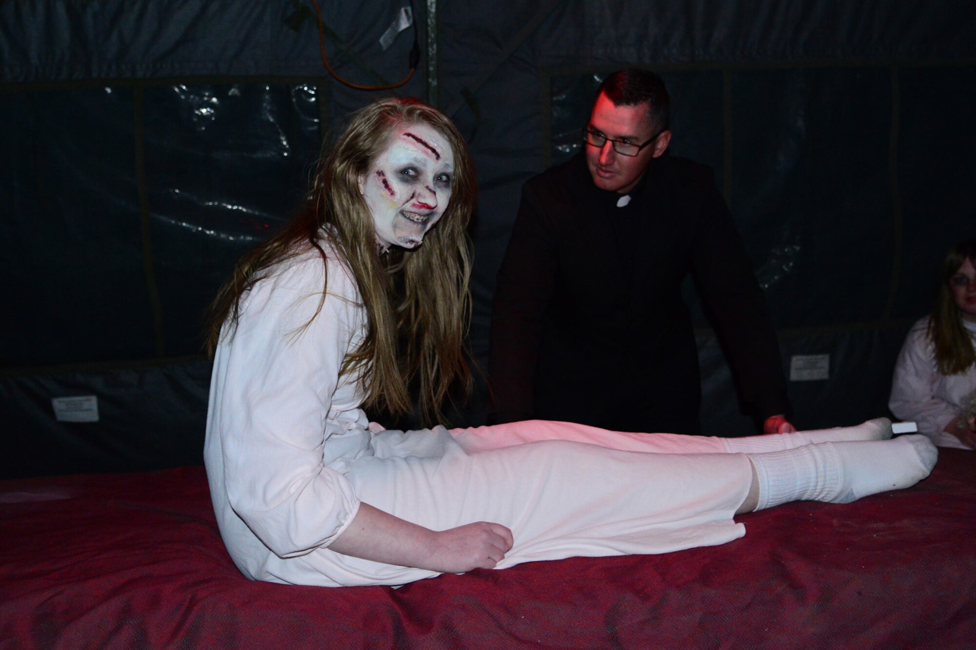 Staff Sgt. Adam Will, 819th RED HORSE Squadron heavy equipment craftsman (right), and Emma Comp, dependent of Senior Master Sgt. William Comp, act out a scene during Malmstrom’s haunted house at the FamCamp Annex on Oct. 25. More than 100 people attended the event and more than $250 was raised for the Great Falls Community Food Bank. (U.S. Air Force photo/Airman 1st Class Collin Schmidt)