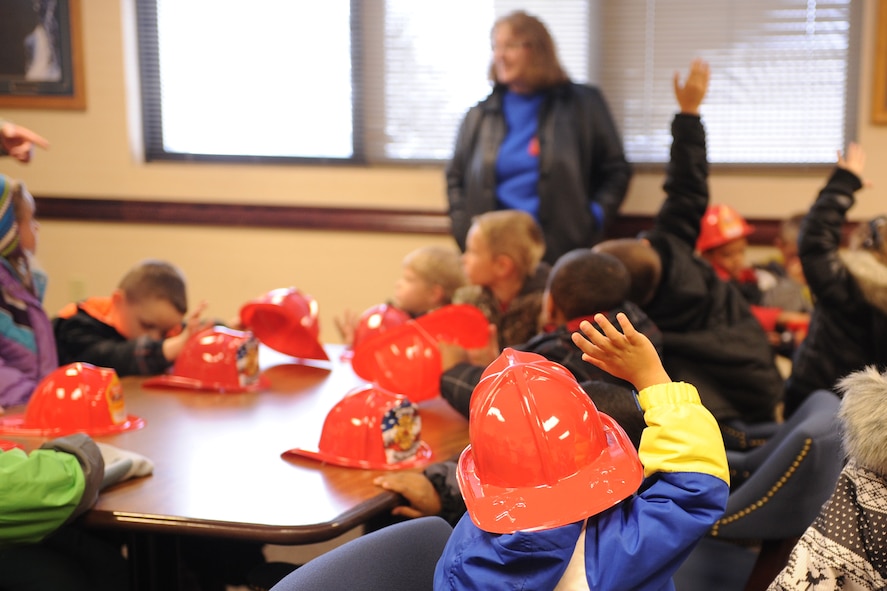 Loy Elementary School kindergarteners raise their hands to ask questions during the annual base fire department tour on Oct. 28. The annual event, typically scheduled for fire prevention week, aims to education children on fire safety. (U.S. Air Force photo/Senior Airman Katrina Heikkinen)
