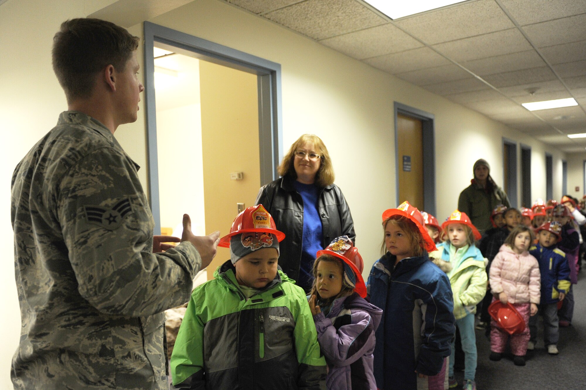 Senior Airman Joshua Grohe, 341st Civil Engineer Squadron firefighter, shows Loy Elementary School kindergarteners his sleeping barracks during a base fire department tour Oct. 28. Grohe, along with Airman 1st Class Joshua Bailey, Staff Sgt. Dustin Beckley, and Tech. Sgt. Michael Gagnier, all 341st CES members, volunteered to host the event. (U.S. Air Force photo/Senior Airman Katrina Heikkinen)