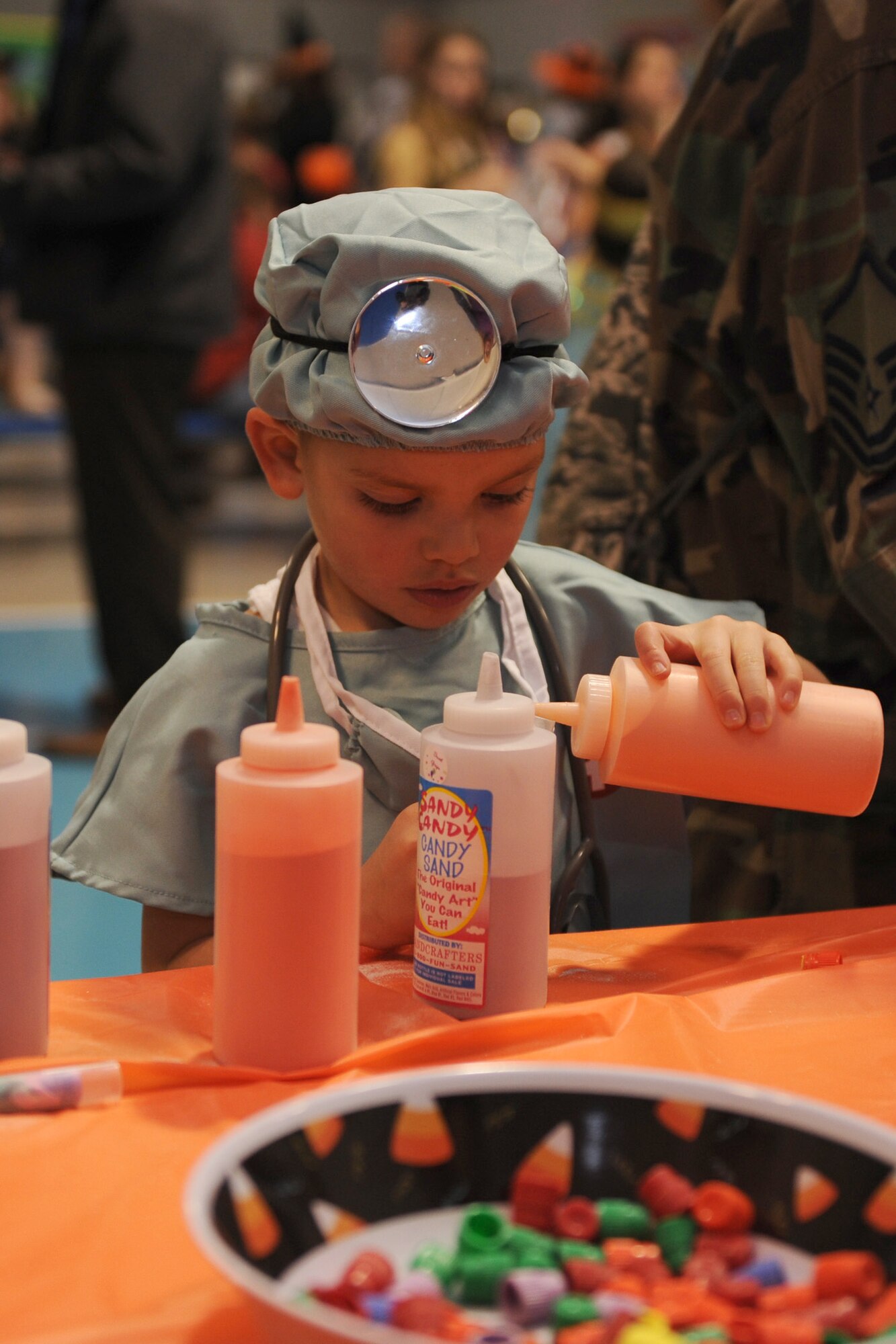 Omar Cortes Jr., 4; dependent of Master Sgt. Omar Cortes, 341st Logistics Readiness Squadron traffic management quality assurance NCO in charge, and Kathryn Cortes, 341st Contracting Squadron contracting intern; plays with candy sand during the annual fall festival at the youth center Oct. 25. Children had the chance to play various carnival games, win prizes and decorate pumpkins. (U.S. Air Force photo/Senior Airman Katrina Heikkinen)