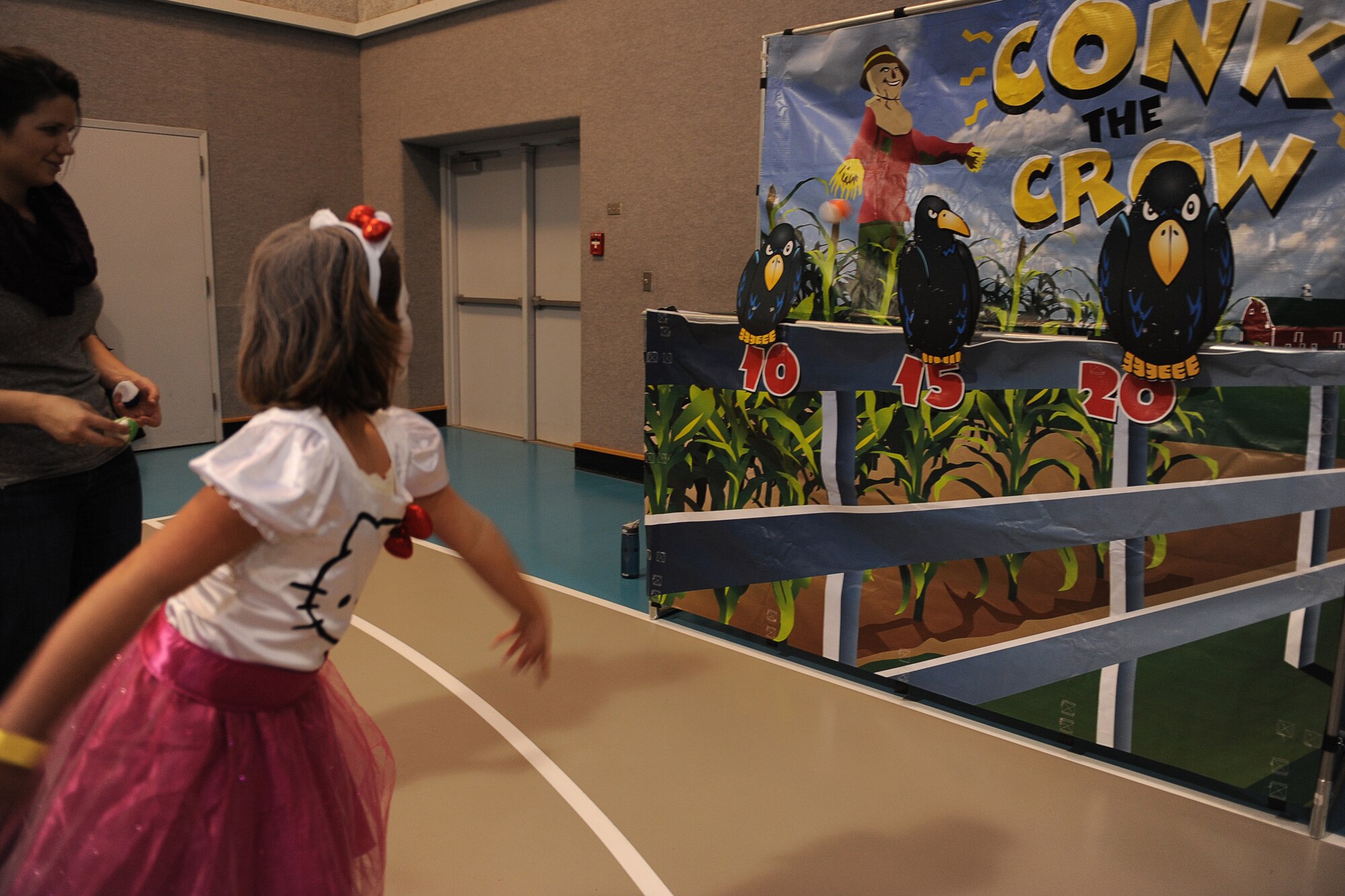 A girl dressed as Hello Kitty throws a ball at a crow at the conk the crow station during the annual Malmstrom Youth Center Fall Festival on Oct. 25. Children of all ages attended the event in costume and were awarded prizes by age categories for the best costumes. (U.S. Air Force photo/Senior Airman Katrina Heikkinen)