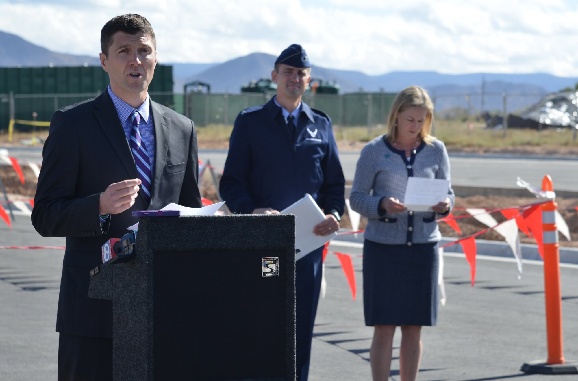 New Mexico Environment Department Secretary Ryan Flynn spoke at a news conference at the site of the fuel plume aquifer test.  This test will monitor the effect of groundwater pumping on the aquifer, providing data vital to employing interim cleanup efforts and  final remedy development.  In the background is Albuquerque Bernalillo County Water Utility Authority commissioner Maggie Hart-Stebbins, right, and Kirtland installation commander Col. Tom Miller. (Photo by Ken Moore)