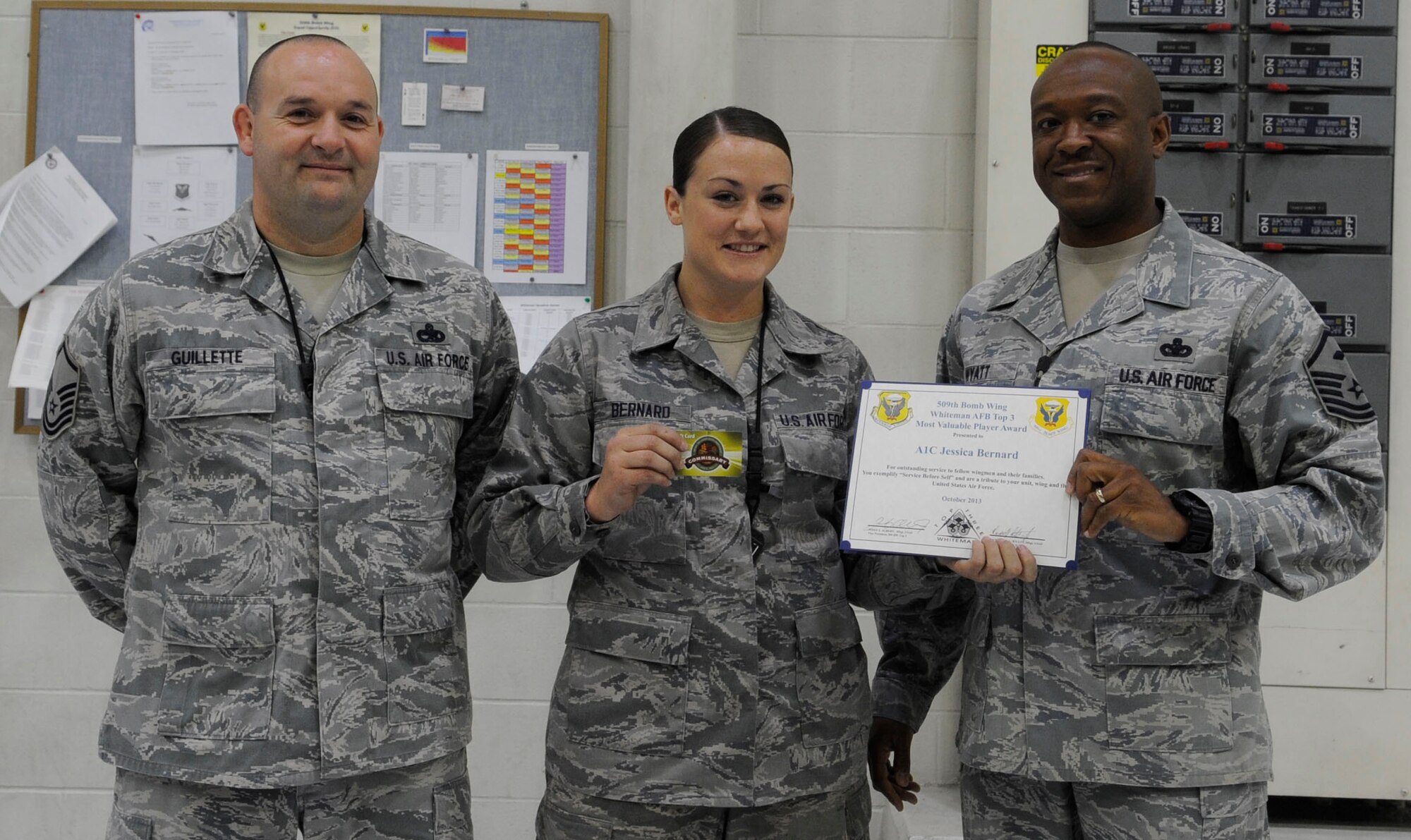 Airman 1st Class Jessica Bernard, 509th Maintenance Squadron aerospace ground equipment technician, receives the Whiteman Top III MVP Award from Master Sgt. Randolph Wyatt, Whiteman Top III council member, at Whiteman Air Force Base, Mo., Oct. 24, 2013. The Top III MVP award is presented monthly to recognize high levels of professionalism throughout the enlisted corps. Bernard works in a flight that is responsible for maintaining more than 700 pieces of equipment valued at more than $58 million. She coordinated eight major fundraisers in Kansas City that generated more than $9,000 to be used for squadron events. Also pictured is Master Sgt. Kevin Guillette, the AGE flight NCO in charge. (U.S. Air Force photo by Staff Sgt. Alexandra M. Boutte/Released)