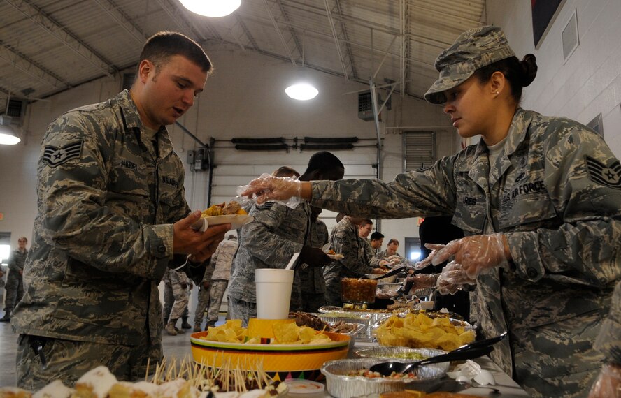 Tech. Sgt. Lizmarie Linares, 509th Medical Operations Support Squadron physical therapy technician, fills a plate with authentic Hispanic food for Staff Sgt. Adam Harney, 509th Civil Engineer Squadron heating, ventilation, air and cooling technician, during the Hispanic Heritage Month closing ceremonies at Whiteman Air Force Base, Mo., Oct. 17, 2013. Latin language and food illustrate the strong Hispanic influence on American society.  (U.S. Air Force photo by Staff Sgt. Alexandra M. Boutte/Released)