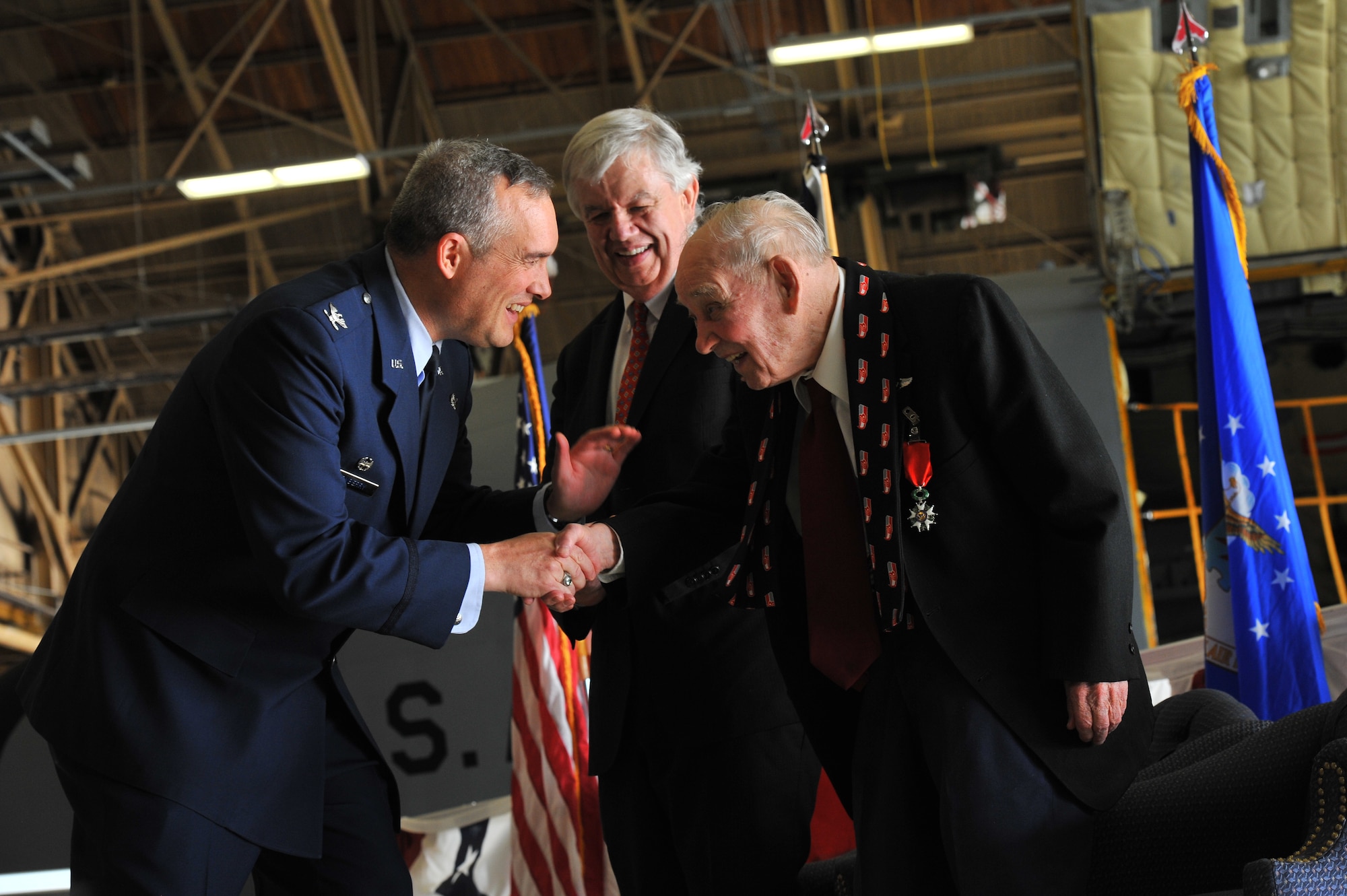 Col. Brian Newberry, 92nd Air Refueling Wing commander, congratulates U.S. Air Force retired Maj. Clarence Grimes on Oct. 25, 2013, at Fairchild Air Force Base, Wash., while Mr. Jack Cowan, Honorary Consul of France, gathers with them. The 92-year old was honored with the highest recognition by the French government for his contributions almost 70 years ago to defend and preserve the independence of France.  (U.S. Air Force photo by Staff Sgt. Veronica Montes/Released)