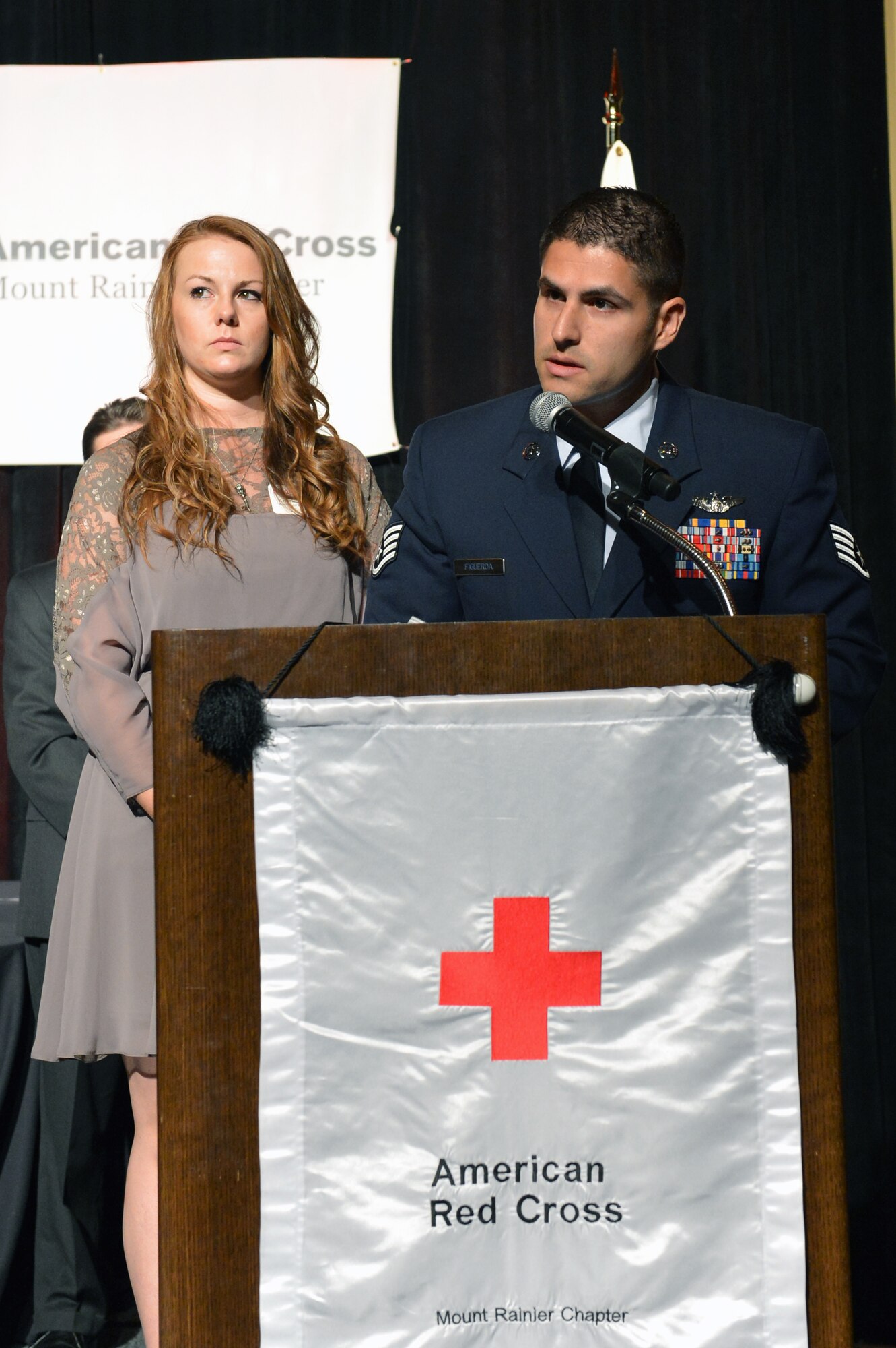 Staff Sgt. Angelo Figueroa, 10th Airlift Squadron loadmaster, accompanied by his wife Kristine give their acceptance speech at the Mount Rainier Chapter Red Cross Heroes Breakfast, Oct. 23, 2013 in Tacoma, Wash. The Figueroa's were the first on scene to a traffic accident that occured earlier this year and immediately started rendering assistance. (U.S. Air Force photo/Staff Sgt. Jason Truskowski)