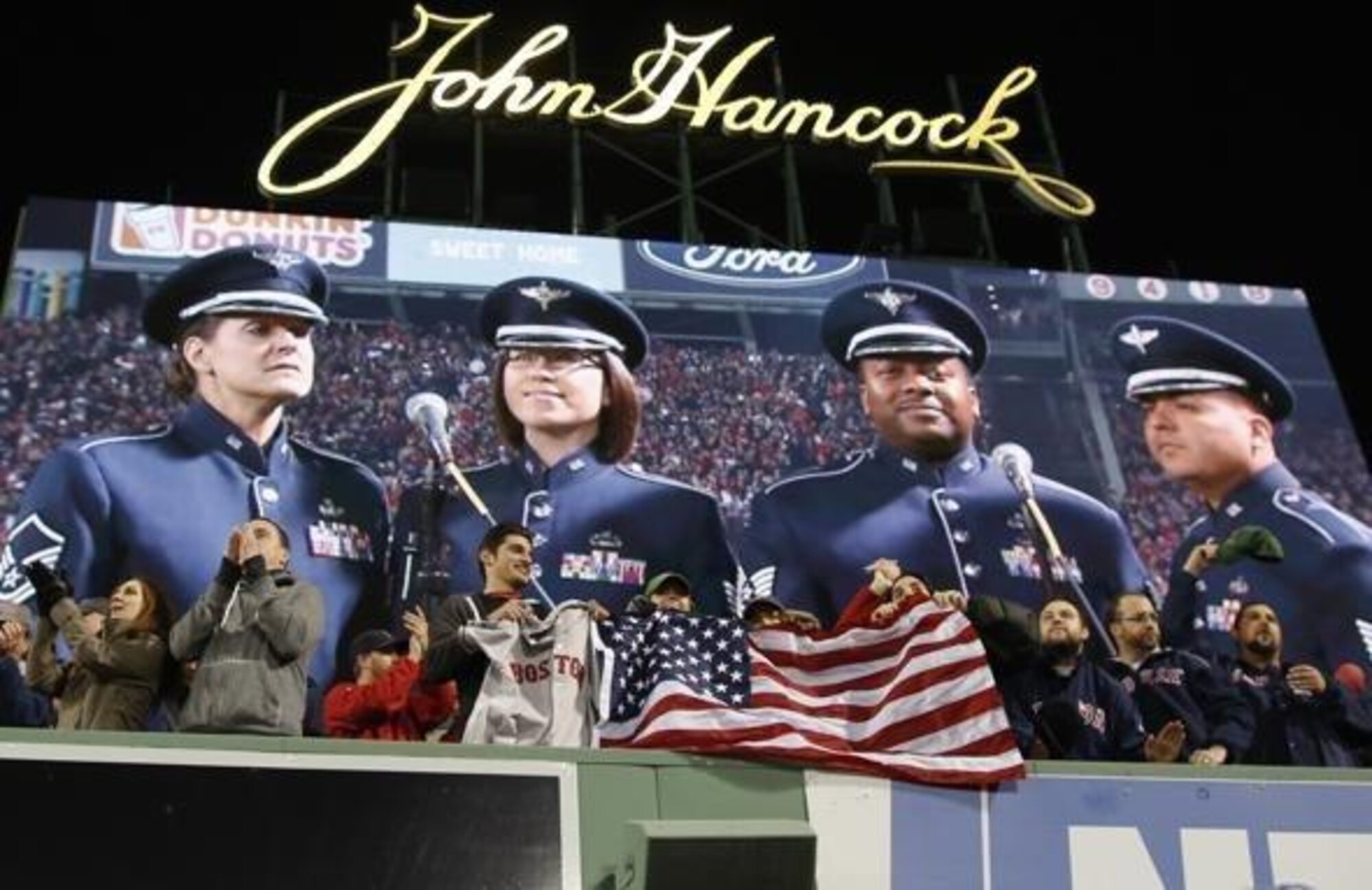(Left to right) Master Sergeant Jennifer Dashnaw, Staff Sergeant Rachel Webber, Technical Sergeant Niko Ellison, Technical Sergeant Quez Basquez, of the United States Air Force Heritage of America Band are getting ready to sing "God Bless America" during the seventh-inning stretch of Game 6 of the World Series. (photo from boston.com)