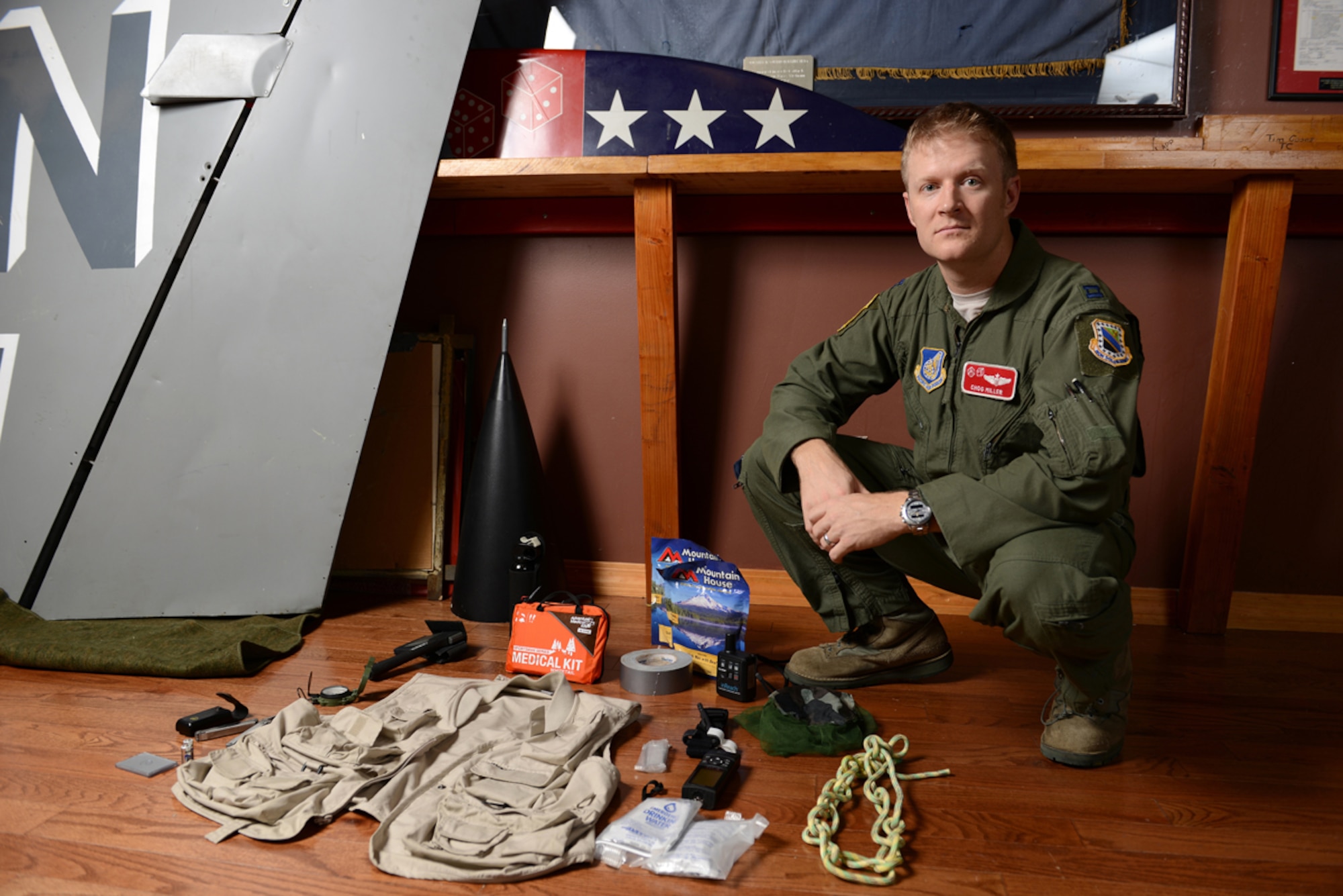 Air Force Capt. Matthew Miller, 90th Fighter Squadron F-22 pilot, shows the survival equipment he packs when he flies his Piper Super Cub airplane. A second-generation Air Force pilot, Miller recently had to rely on his piloting skills during an Alaska hunting trip when the weather turned nasty. (U.S. Air Force photo/David Bedard)