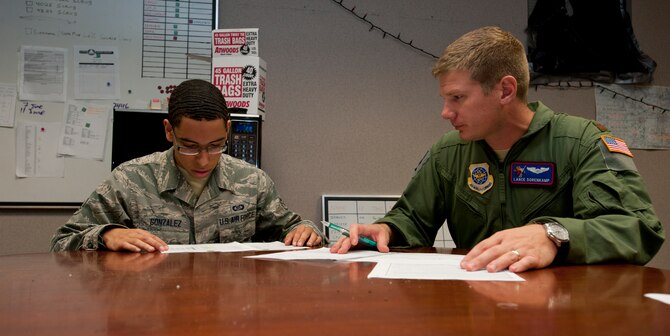 Airman 1st Class Carlos Gonzalez, 349th Air Refueling Squadron aviation resource manager, reviews flight records with Maj. Lance Dorenkamp, 349th ARS assistant director of operations, Oct. 30, 2013, at McConnell Air Force Base, Kan. Gonzalez, who was selected as the 22nd Air Refueling Wing spotlight performer for the week of Oct. 21 to 25, is responsible for keeping track of the various records in the squadron to keep the aircrew flight-qualified. (U.S. Air Force photo/Airman 1st Class Victor J. Caputo)