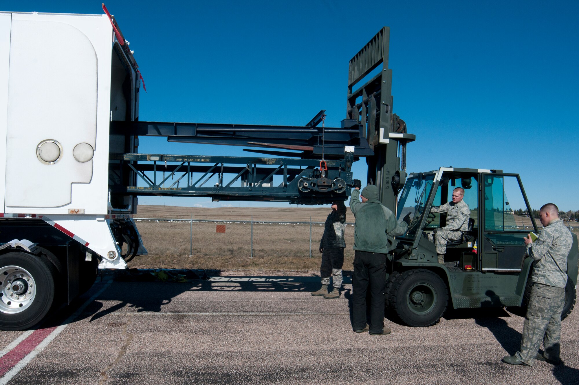 131030-F-BR137-158
With the rest of his team providing guidance, Senior Airman Justin Peeples, 90th Missile Maintenance Squadron missile handling technician, backs a rocket motor carriage out of a transport erector using a forklift during training Oct. 30, 2013, in the Missile handling section controlled area on F.E. Warren Air Force Base, Wyo. (U.S. Air Force photo by Airman 1st Class Jason Wiese)
