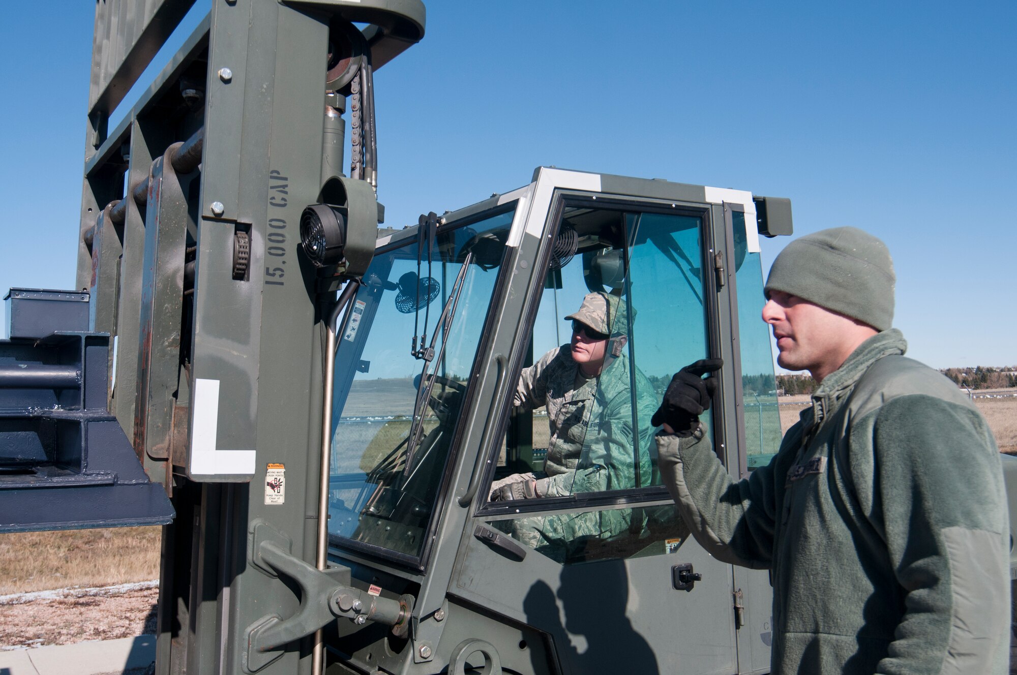 131030-F-BR137-119
Tech. Sgt. Stephen Silverman, 90th Missile Maintenance Squadron missile handling team chief, guides Senior Airman Justin Peeples, 90th MMXS missile handling technician, as he positions a forklift capable of lifting 15,000 pounds and fitted with specialized equipment to remove rocket motor carriages during training Oct. 30, 2013, in the Missile handling section controlled area on F.E. Warren Air Force Base, Wyo. (U.S. Air Force photo by Airman 1st Class Jason Wiese)
