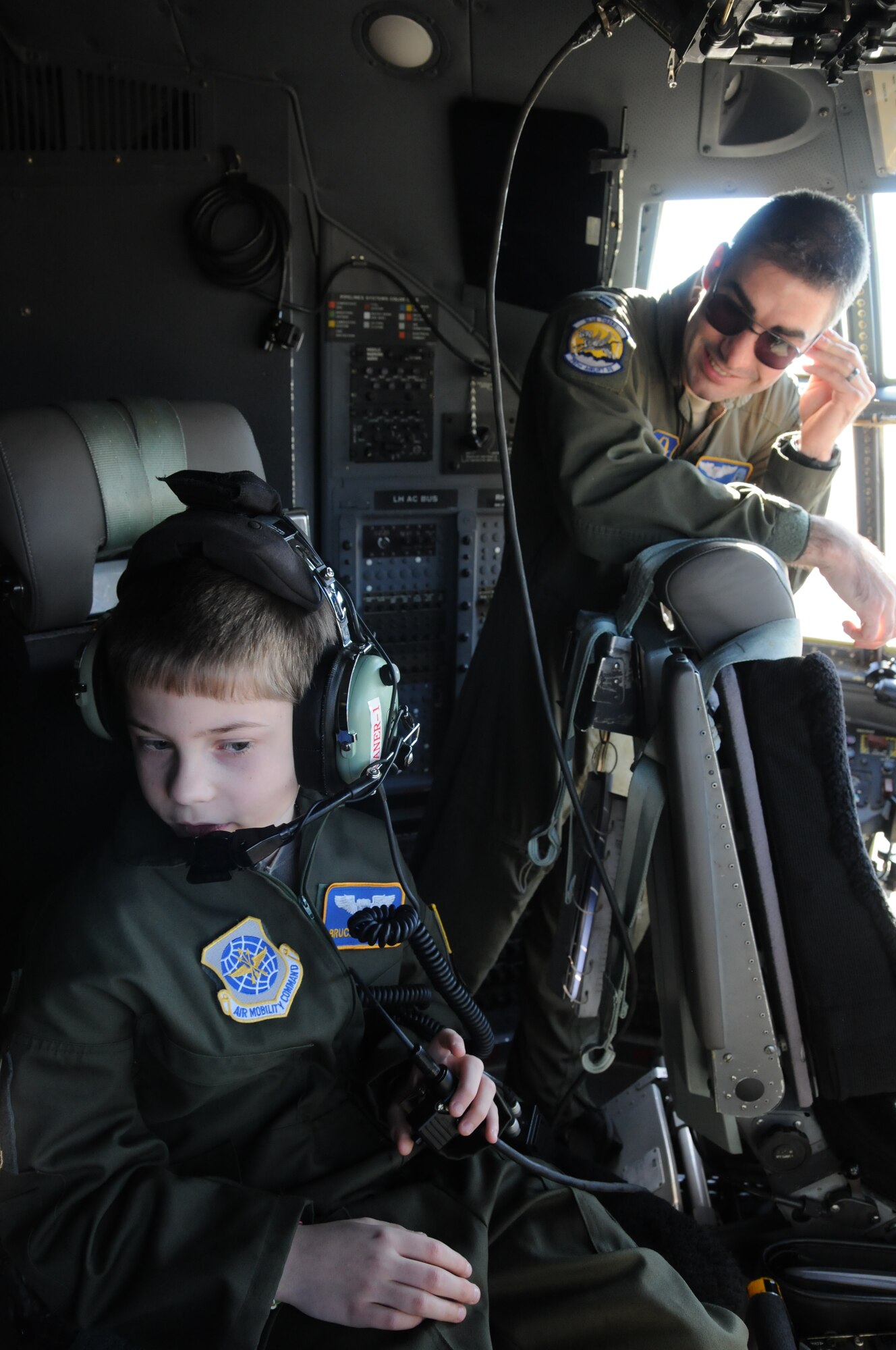 Bruce Cellars sits in the flight engineer's chair of a C-130H Hercules aircraft as Capt. Jonathan Blackann, a 757th Airlift Squadron pilot, tells him about the controls during a visit to Youngstown Air Reserve Station, Ohio, Oct. 30, 2013. (U.S. Air Force photo/Eric M. White)